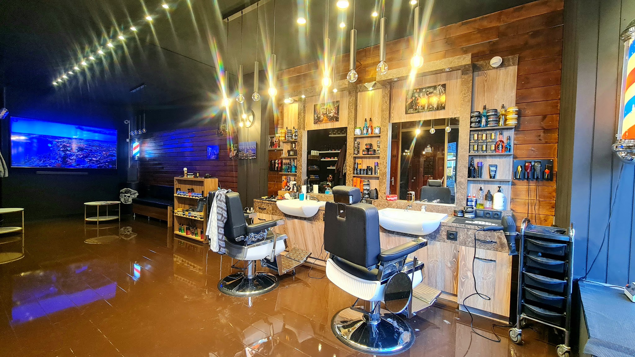 Overzicht van het interieur met verlichte spiegels en kappersstoelen